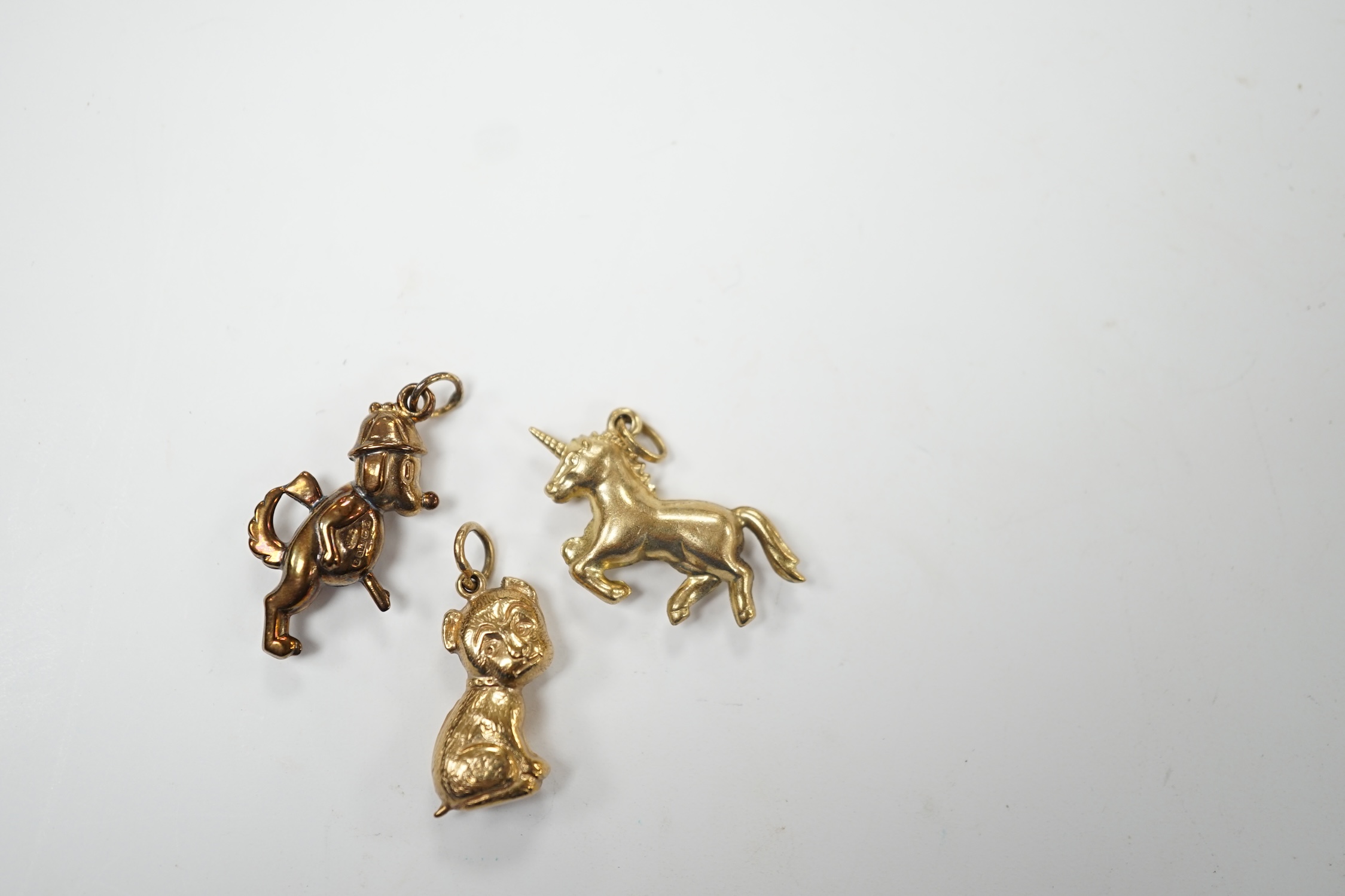 Two 9ct gold charms including 'gun dog', 24mm and a yellow metal unicorn charm. Good condition.